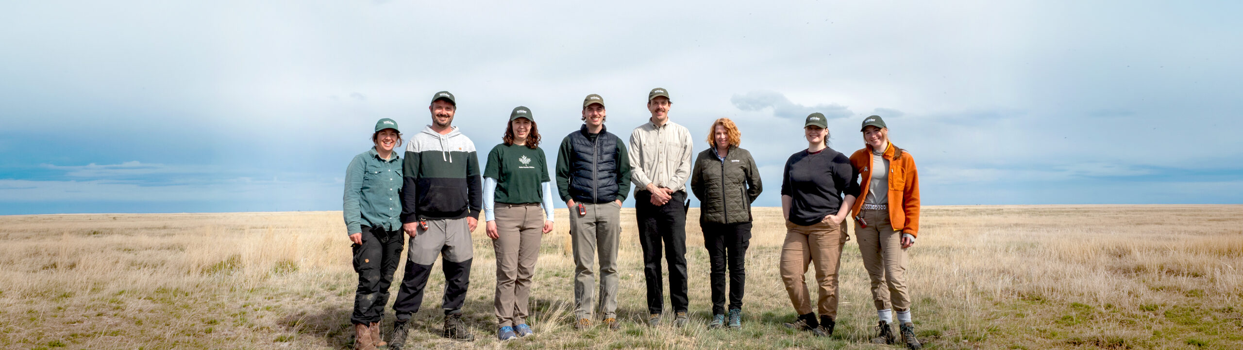 A group of people standing in a line in a field.
